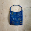 Sac tote bag en organza bleu indigo transparent, brodé de motifs inspirés de Marseille — le soleil, la mer, les poissons et la Bonne Mère — accompagné de l’inscription au soleil by Honoré. Une création légère et artisanale qui capture l’esprit méditerranéen et ensoleillé de la marque.