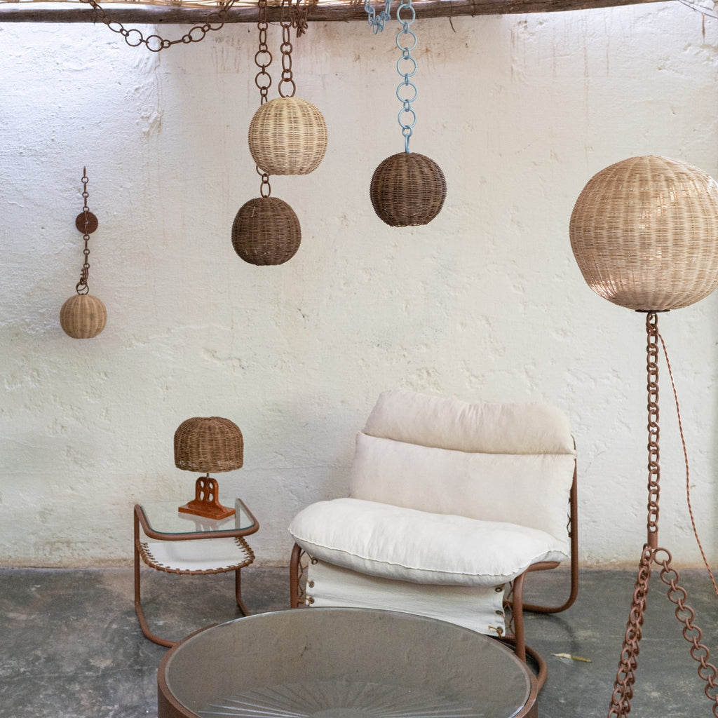 Applique murale en rotin suspendues à des chaînes décoratives en métal.