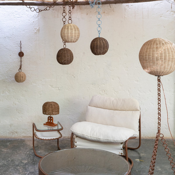 Applique murale en rotin suspendues à des chaînes décoratives en métal.