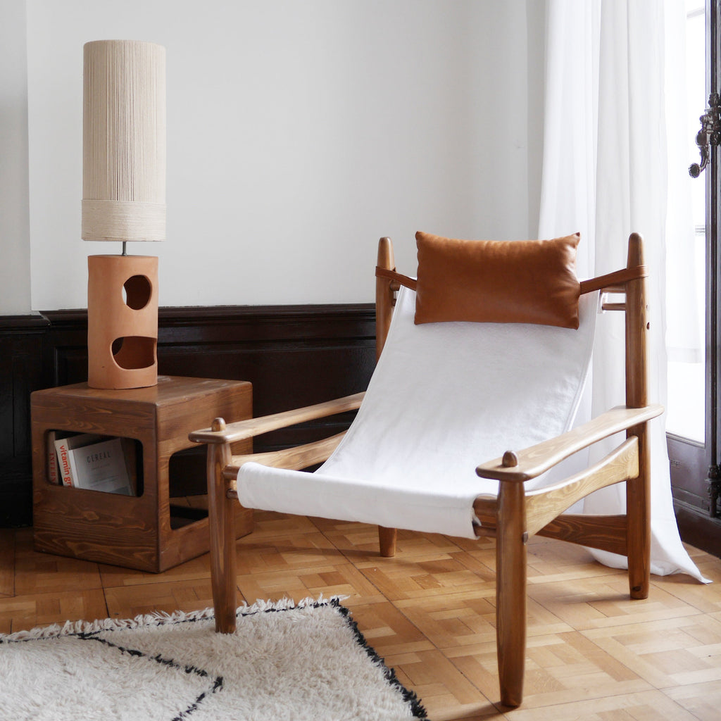 Lampe à poser en céramique artisanale terracotta, forme géométrique sculpturale avec abat-jour en raphia — luminaire design pour salon ou chambre.