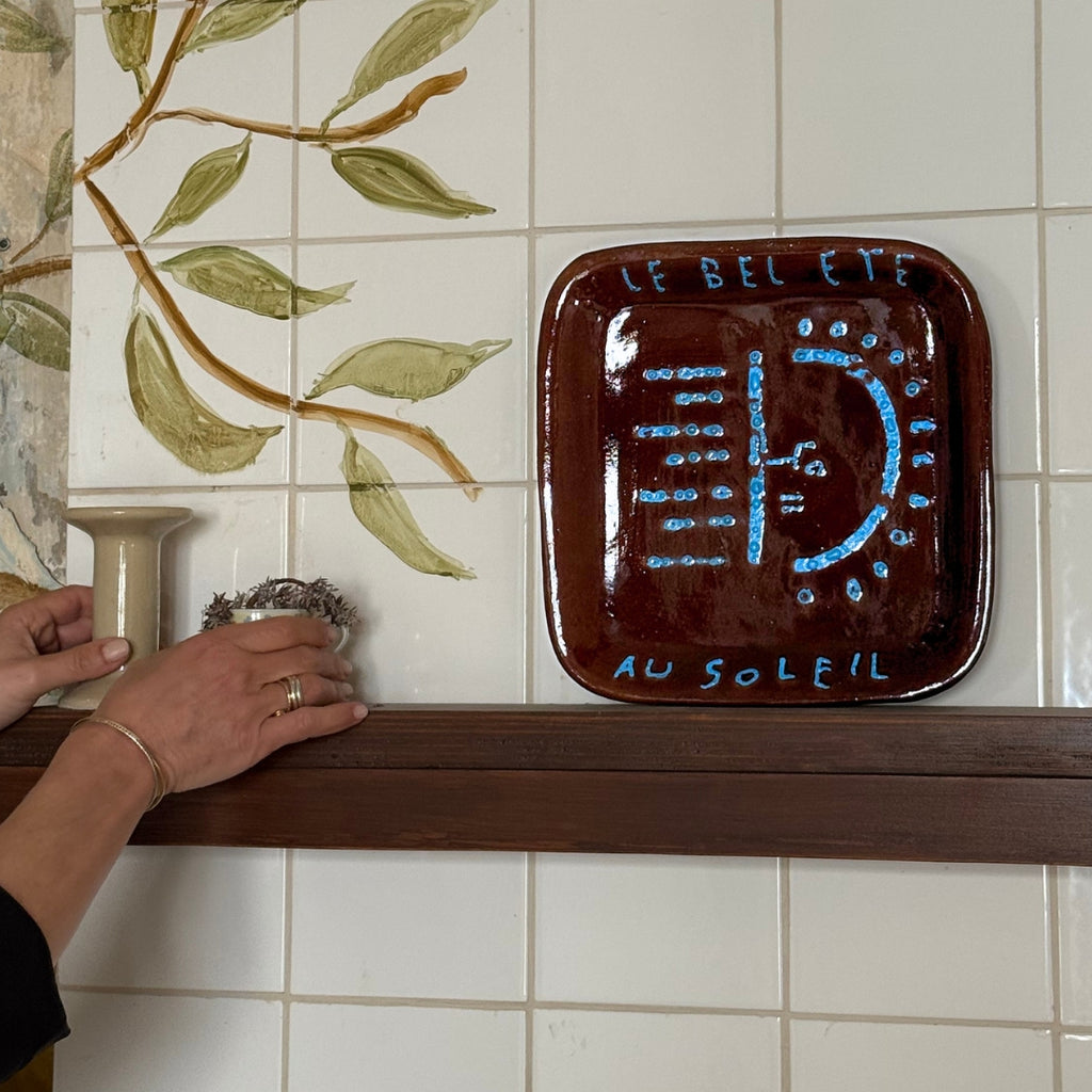 Assiette accroché au mur, vaisselle artisanale avec motifs soleil, combinée à des bougeoirs