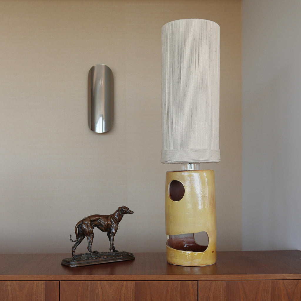 Lampe à poser en céramique artisanale jaune ocre, forme géométrique sculpturale avec abat-jour en corde — luminaire design pour salon ou chambre.