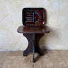 Assiettes en céramique faites main marron avec motifs solaires bleus disposées sur un tabouret en bois foncé