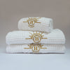 Serviettes de bain gaufrées en coton nid d’abeille blanc ornées de broderies soleil signées Honoré. Taille 50x100 80x160 