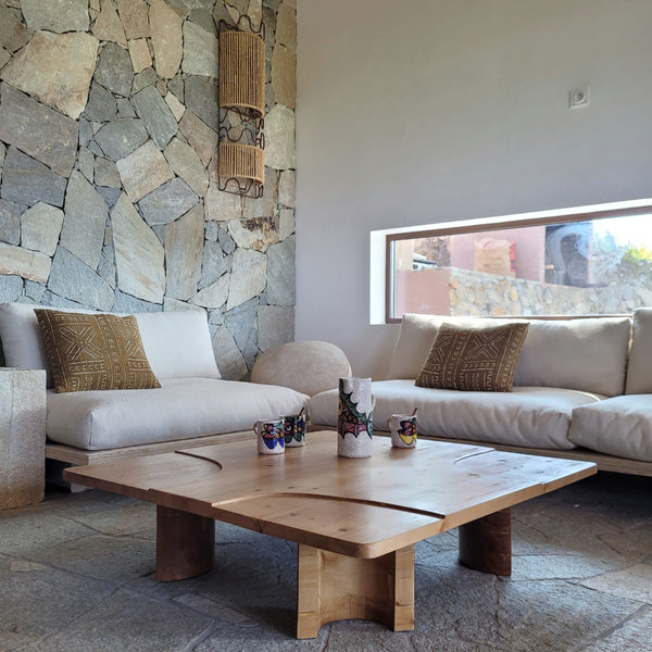 table carré en bois vernis pied arrondis forme organique détail sur le plateau dans salon Provence en pierre matière naturelle 