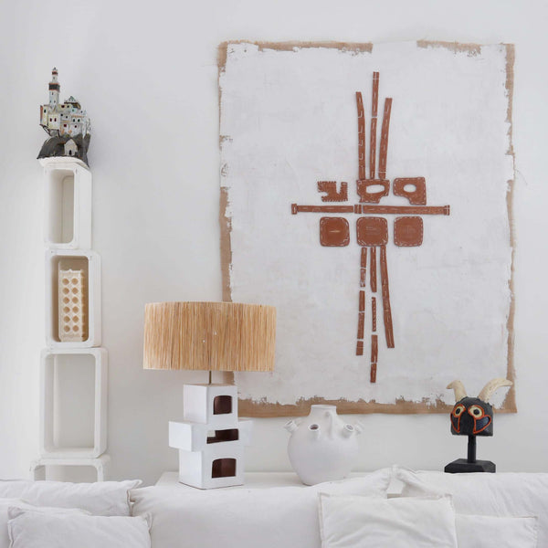 Lampe à poser en céramique artisanale blanc, forme géométrique sculpturale avec abat-jour en raphia naturel — luminaire design pour salon ou chambre.